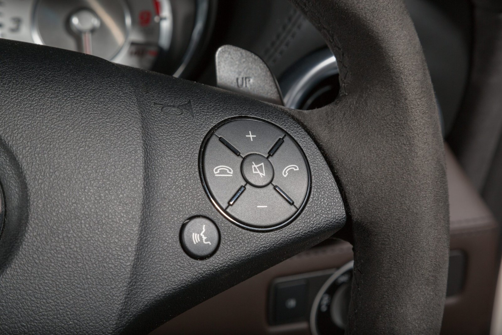 A closeup shot of call buttons on the steering wheel of a modern car